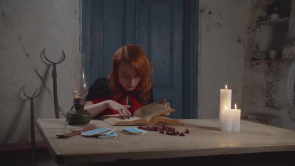 Bruja blanca concentrada leyendo libro de magia indoor — Vídeo de stock
