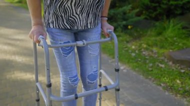 Yaşlı, buruşuk ellerle gezen, parkta yürüyen, denge ve istikrarı sağlayan, temiz havanın ve boş zamanların tadını çıkaran kadınların yakın çekimi..