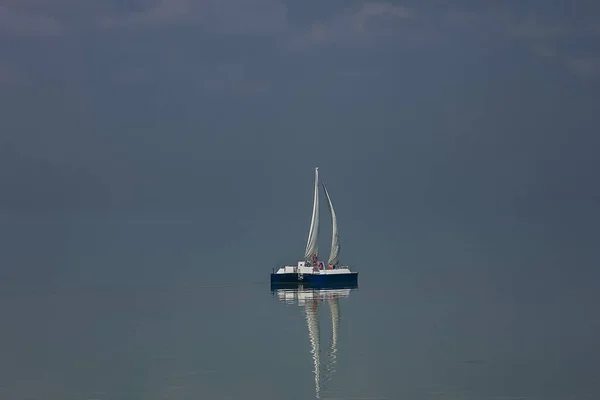 Güzel bir gökyüzü, üzerinde bulutlar olan denizde bir tekne.