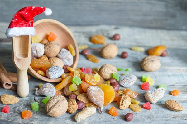 Weihnachtsmann Hut Mit Getrockneten Früchten Und Nüssen Auf Holzgrund — Stockfoto