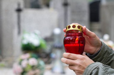 Azizler günü ve mum Işık mezarlığı üzerinde bellek ile Hıristiyan el