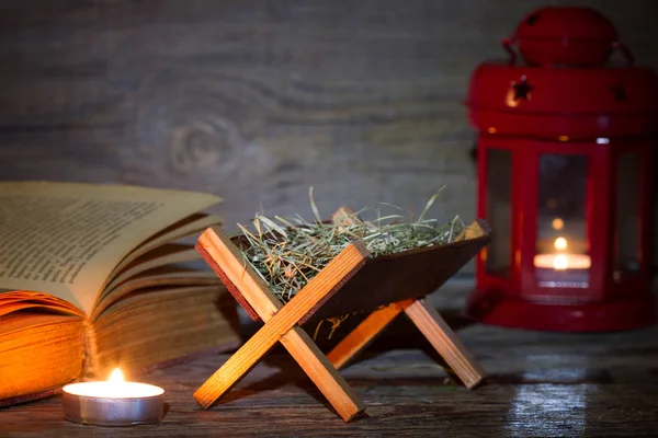 飼い葉桶のキリスト降誕シーンのランタンと夜背景クリスマスの聖書 — ストック写真