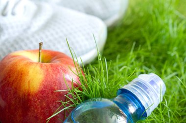 Spor ayakkabı ve sağlıklı gıda çim üzerinde açık koşu ve spor etkin livestyle konseptiyle