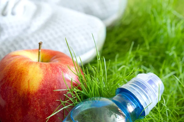 Spor ayakkabı ve sağlıklı gıda çim üzerinde açık koşu ve spor etkin livestyle konseptiyle