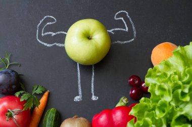 Vitaminlerin gücü diyet soyut kavramı ile yeşil kaslar kara tahta üzerinde elma