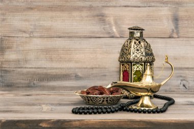 Oryantal lamba ve tarihleri ahşap arka plan üzerinde. Tespih ile şenlikli natürmort