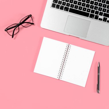 En az düz yatıyordu. Laptop, defter, pembe bir arka plan üzerinde gözlük