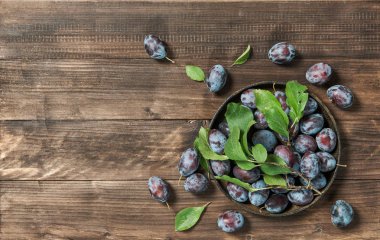 Yeşil erik meyve rustik ahşap arka plan üzerinde bırakır