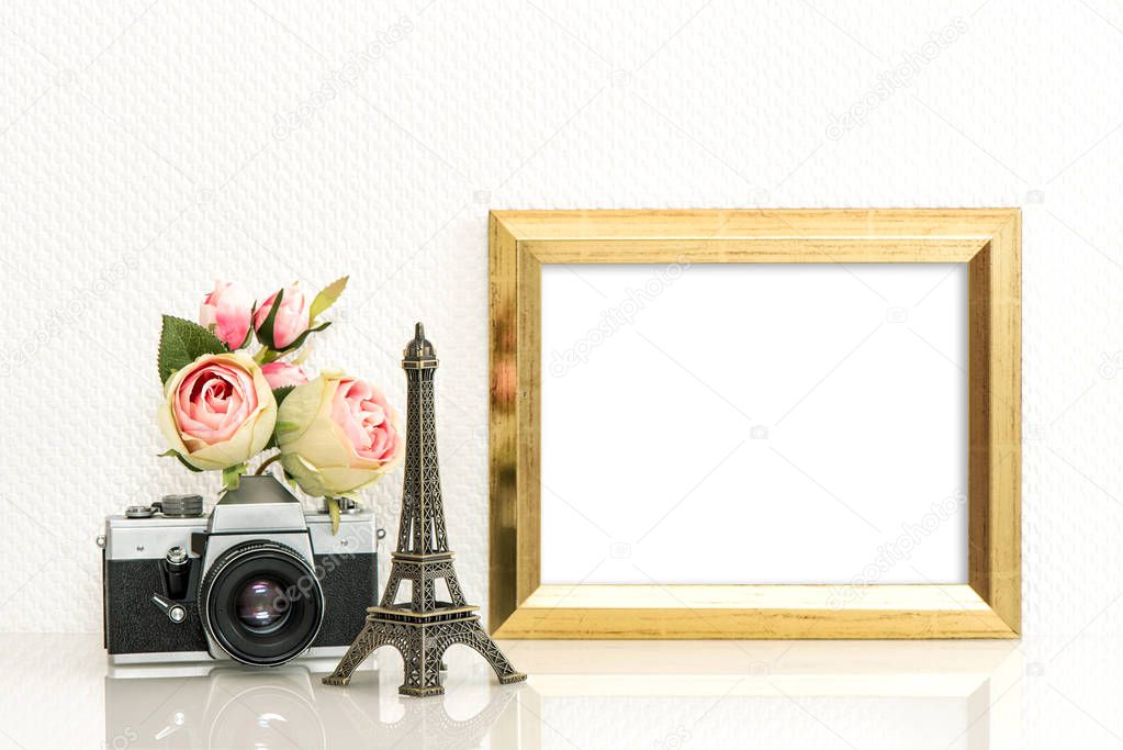 Golden picture frame, rose flowers and vintage camera. Paris travel concept