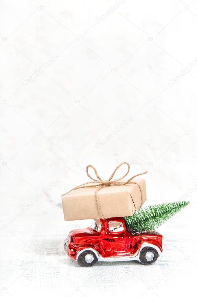Red car with gift box and Christmas tree. Winter holidays decoration