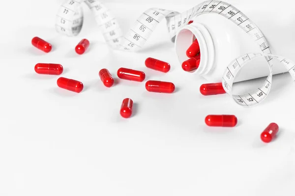 红色药丸和测量带在白色背景 健康和排毒概念 — 图库照片