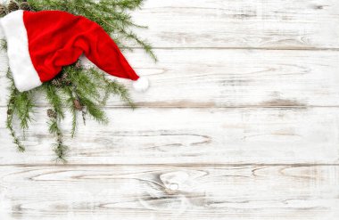 Çam ağacı dalları ve ahşap arka plan üzerinde kırmızı şapka. Noel dekorasyon