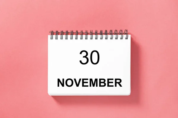 Calendar book for date on pink background. 30 november