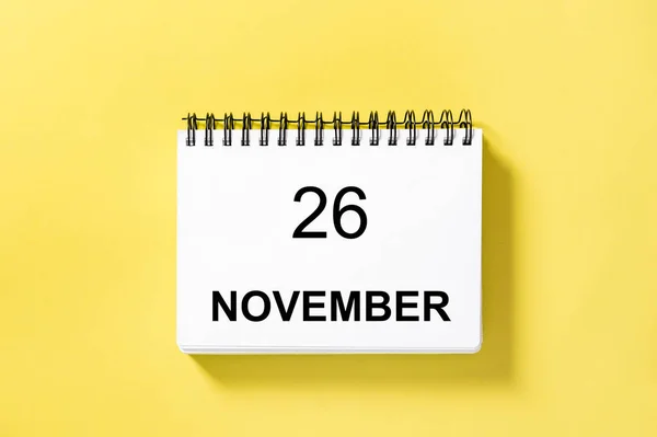 Calendar book for date on yellow background. 26 november