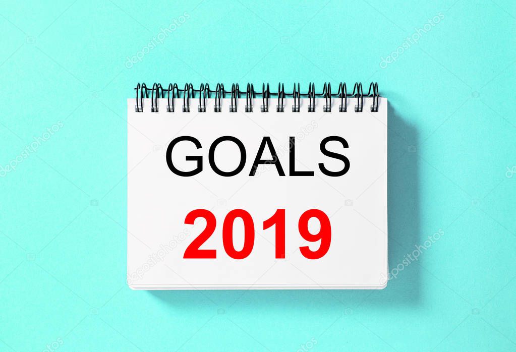 Spiral book on blue background. Paper notebook Goals 2019