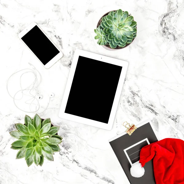 Tablet PC, mobile phone, succulent plants. Office desk with Christmas decoration. Flat lay mock up for social media