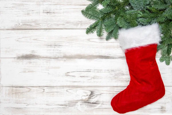 圣诞节装饰红色袜子与绿色松树树枝在明亮的木背景 — 图库照片