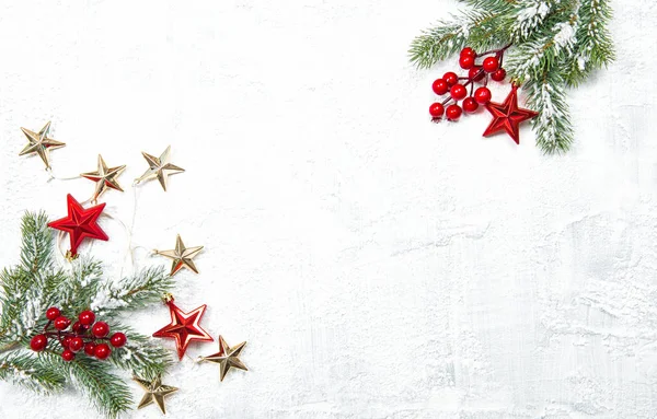 Kırmızı Noel dekorasyonu ve beyaz zemin üzerine yeşil çam ağacı dalları