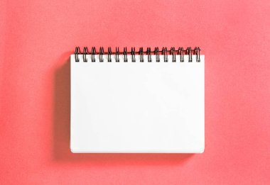 Mercan renkli arka plan üzerinde spirale kitap. Kağıt defter