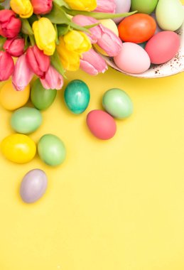Paskalya yumurta dekorasyon ve sarı arka plan üzerinde renkli Lale çiçek
