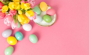 Paskalya yumurtaları ve Lale çiçek dekorasyon pembe bir arka plan üzerinde