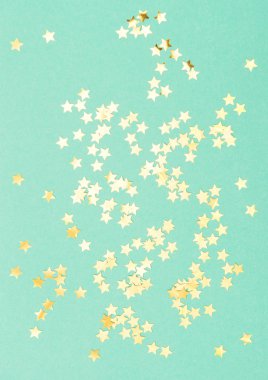 Altın konfeti nane renk düz arka plan yıldız yatıyordu