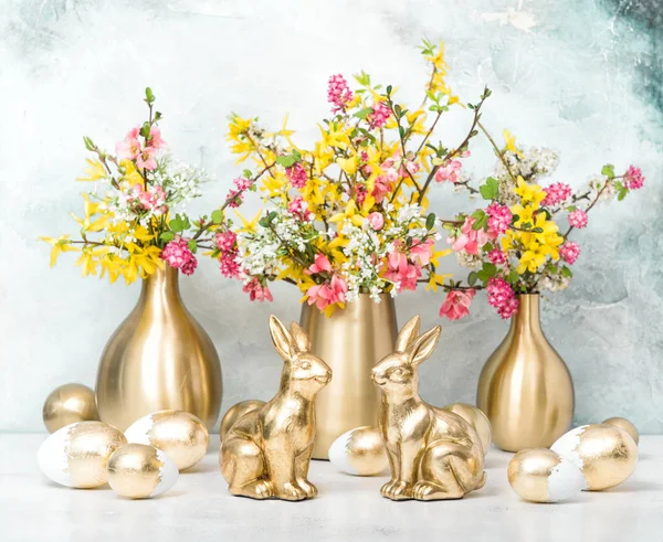 Easter bunnies golden eggs flower decoration — Stock Photo, Image