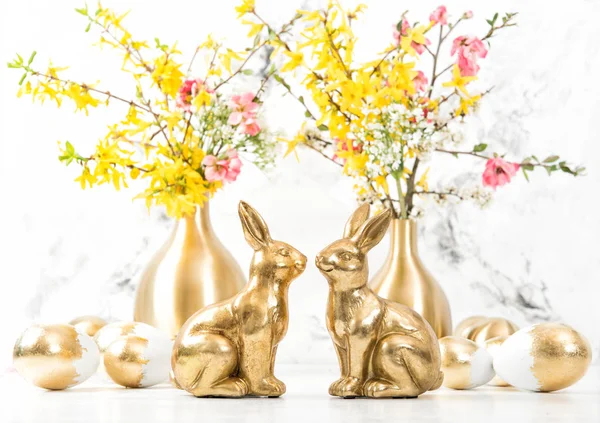 Easter bunnies golden eggs flowers decoration — Stock Photo, Image
