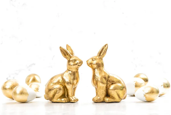 Golden bunnies Easter eggs white background — Stock Photo, Image