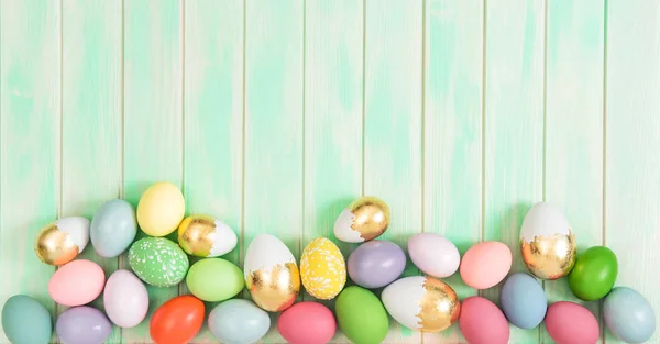 Easter eggs green wooden background — Stock Photo, Image