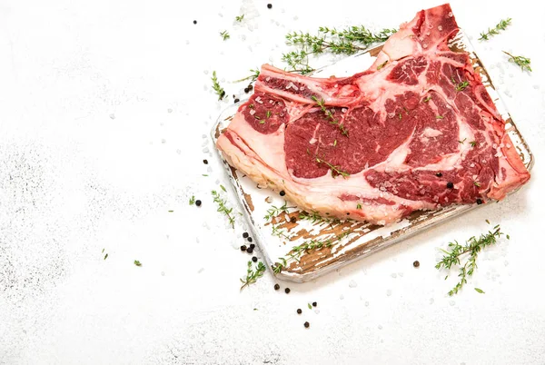 Bife cru carne ervas especiarias mesa branca — Fotografia de Stock
