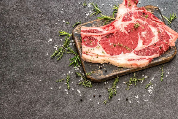Syrové hovězí steak maso byliny koření tmavé kamenné pozadí — Stock fotografie