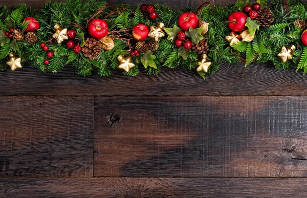 Kerst decoraties slinger rood appel groene dennen takken donker — Stockfoto