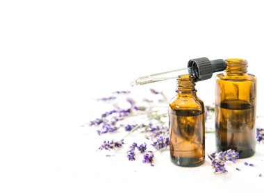 Beyaz arka planda bitkisel yağ ve lavanta akıntıları