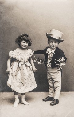 Eski moda giyinmiş komik kız ve oğlanın fotoğrafı. Orijinal film tahılları ve çizikleriyle geçmişe dönük resim