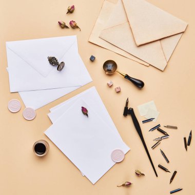 Kopya alanı ile kadınsı Resepsiyon çalışma alanının düz yatıyordu. Kaligrafi stil, kağıt bej renkli arka plan üzerinde. Üstten Görünüm, kare kırpma.