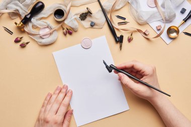 Eller ile kadınsı Resepsiyon çalışma alanının düz yatıyordu. Kaligrafi stil, hat kalem ve kağıt bej renkli arka plan üzerinde tutan eller.