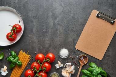 Lezzetli İtalyan yemekleri ile domates için gıda arka plan. Kaşık ve boş karton Pano menüsü veya yemek tarifleri için çeşitli pişirme malzemelerle. Kopya alanı ile üstten görünüm.