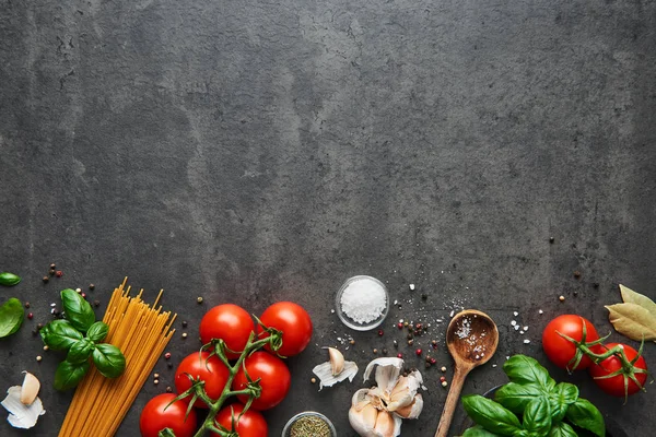 Lezzetli İtalyan yemekleri ile domates için gıda arka plan. Spagetti ve kaşık çeşitli pişirme malzemelerle. Kopya alanı ile üstten görünüm.