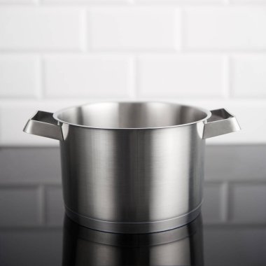 Paslanmaz çelik tencere kapak indüksiyon olmadan arka planda beyaz metro çinilerle soba. Kopya alanı üst ile kare ürün.