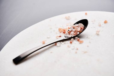 Pembe Himalaya tuz kopya alanı ile mermer kesme tahtası üzerinde siyah kaşık.