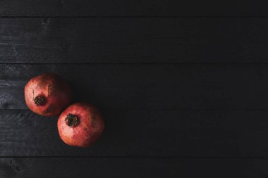 Düz olgun nar meyve siyah ahşap antika arka plan üzerinde yatıyordu. Kopya alanı ile üstten görünüm.