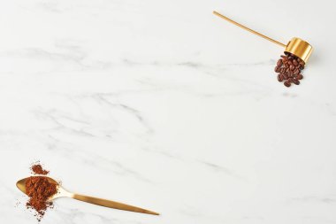 Kahve arka plan kavramı. Altın kaşığı çekilmiş kahve ile yat ve mermer zemin üzerine kahve çekirdekleri ile oymak. Kopya alanı ile üstten görünüm.