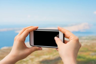 Peyzaj fotoğraf çekme eller. Fotoğrafınız için boş kopya alanı ekranlı akıllı telefon tutarak kadının el atış görünümü kırpılmış.