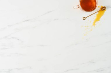 Çay kavramı. Beyaz mermer zemin üzerine üstten görünüm çay Cam Kupası ve bal ile Altın Ayı'yı. Yatay düz lay kopya alanı ile.