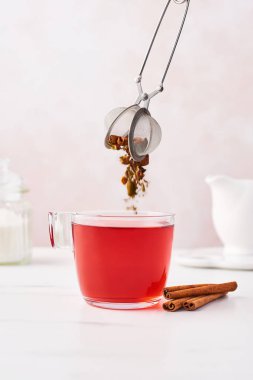 Bir cam fincan çay demlik dışarı kuru otlar ve meyveler fall ile meyve çayı. Mermer masa üstü kadınsı gül arka plan ile. Kopya alanı.