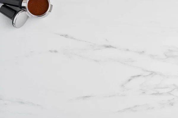 Top view of black coffee tamper and portafilter with gorund coffee on white marble background. Flat lay with copy space. — Stock Image Top View Black Coffee Tamper Portafilter Gorund Coffee White Marble Stock Photo