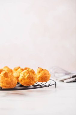 Demet taze kremalı pasta kek çırpma teli ile Fransız tel raf üzerinde ve kopya alanı ile pembe arka plan üzerinde beyaz mermer masada dishtowel. Seçici odak.