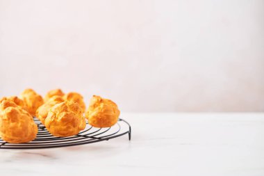 Bir grup Fransız tel raf kopya alanı ile pembe arka plan üzerinde beyaz mermer tablo üzerinde taze kremalı pasta kek. Seçici odak.