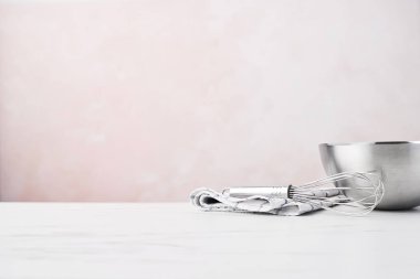 Fırın kavramı. Kopya alanı ile pembe arka plan üzerinde beyaz mermer tablo bulaşık bezi bir çırpma teli ile kase.